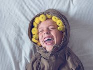 Хлопчик у вінку жовтих квітів — стокове фото