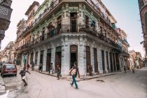 LA HABANA, CUBA - MAY 1, 2018: pedestrians walking on street with old architectural buildings in city of Cuba. — Stock Photo
