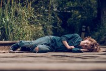 Курчавый мальчик спит на железной дороге — стоковое фото