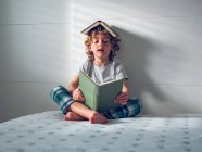 Смешной мальчик читает книгу — стоковое фото