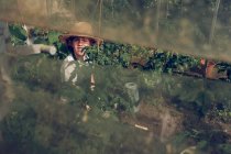 Boy in straw hat standing in hothouse — Stock Photo