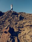 Tour de phare sur colline rocheuse — Photo de stock
