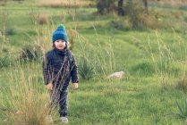Boy standing in sunny field — Stock Photo