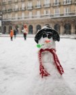 Small snowman in old town street. — Stock Photo