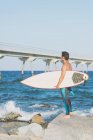 Homem com prancha de surf em pé na costa — Fotografia de Stock