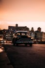 Voiture vintage conduite sur la route au coucher du soleil — Photo de stock