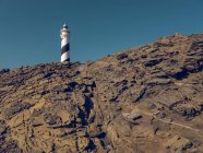 Lighthouse tower on rocky hill — Stock Photo