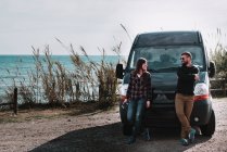 Couple leaning at van at seaside — Stock Photo