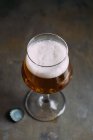 Glass of lager beer on grey background — Stock Photo