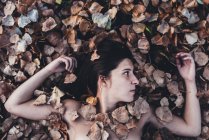 Голая женщина в листве — стоковое фото