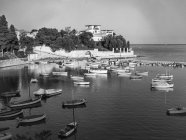 Black and white shot of city bay with tranquil water and boats floating in sunlight, Belgium. — Stock Photo