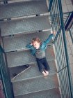 Menino deitado com skate nas escadas — Fotografia de Stock