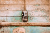 Altes Münztelefon hängt an schäbiger verwitterter Außenwand des Gebäudes — Stockfoto