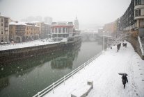 Canale del fiume e strada coperta di neve a Bilbao, Spagna . — Foto stock