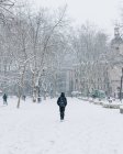 Person with backpack walking on snowy street in Bilbao, Spain. — Stock Photo