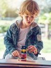Мальчик играет с деревянными блоками башни — стоковое фото