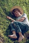 Мальчик лежит на зеленой свежей траве — стоковое фото