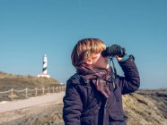 Boy standing with binoculars — Stock Photo