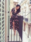 Donna in piedi sul balcone in città — Foto stock