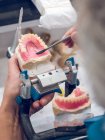 Зубной техник наносит вещество на протез — стоковое фото