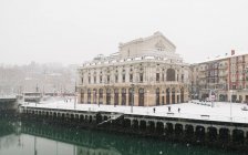 Edificio histórico en el canal fluvial en invierno en Bilbao, España . - foto de stock