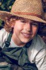 Хлопчик з завитками в солом'яному капелюсі — стокове фото