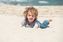 Junge liegt am Strand — Stockfoto