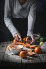 Hands peeling blood oranges — Stock Photo
