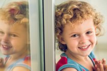 Lächelnder Junge am Fenster — Stockfoto