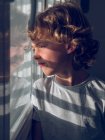Cute boy looking out window — Stock Photo