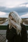 Блондинка стоїть на пішохідному мосту — стокове фото