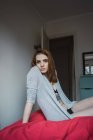 Junge Frau sitzt auf dem Bett — Stockfoto