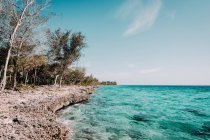 Eau turquoise et littoral rocheux sous le ciel bleu — Photo de stock