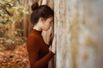 Woman leaning forehead against wall — Stock Photo