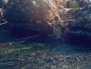Маленький хлопчик стоїть у річці — стокове фото