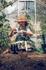 Niño trabajando en invernadero - foto de stock