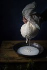 Cropped view of hands of cook squeezing cottage cheese on table. — Stock Photo