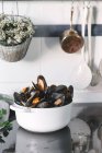 Pot with mussels on kitchen tabletop — Stock Photo