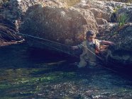 Petit garçon debout dans la rivière — Photo de stock