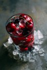 Fresh cherries in glass with ice — Stock Photo