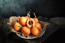 Fresh whole and halved loquats — Stock Photo