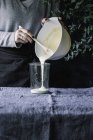 Руки наливая тесто в банку — стоковое фото