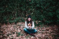 Женщина сидит на осенней листве — стоковое фото