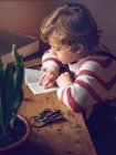 Junge liest Buch am Tisch — Stockfoto