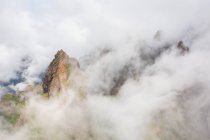 Paisagem de picos de montanha rochosos em nuvens — Fotografia de Stock
