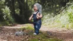 Mignon petit enfant en chapeau gris debout avec des lapins dans le parc — Photo de stock