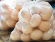 Plastic transparent bags filled with farm fresh eggs — Stock Photo