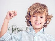 Boy in shirt pulling tooth out with thread while looking at camera — Stock Photo