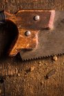 Gros plan de la scie à main rouillée sur la surface en bois — Photo de stock