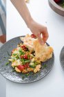 Main humaine avec assiette d'omelette, légumes et pain — Photo de stock